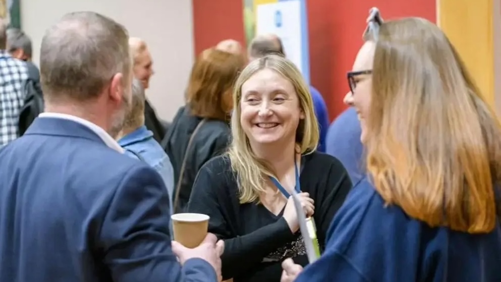 People enjoying conversations and smiling at a gathering.