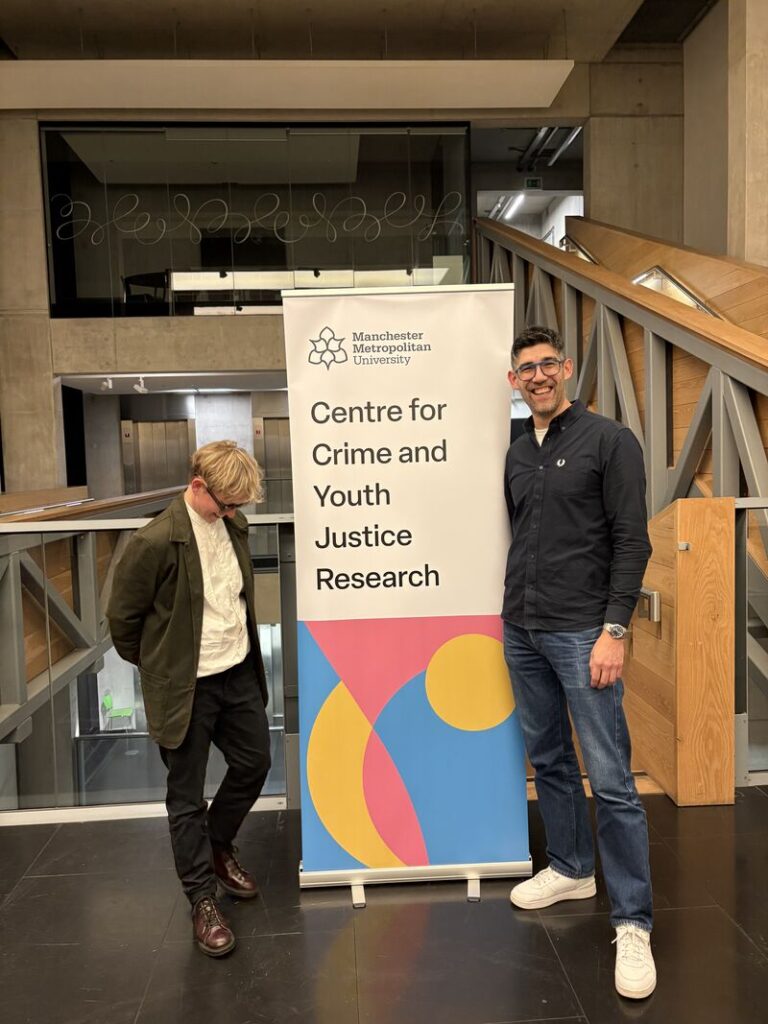 CCYJR Co-Directors Paul and Deborah stand beside a banner reading "Centre for Justice and Equality Research".