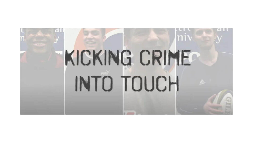 A group of young men stands together, promoting the message "Kicking Crime into Touch" in a community initiative.